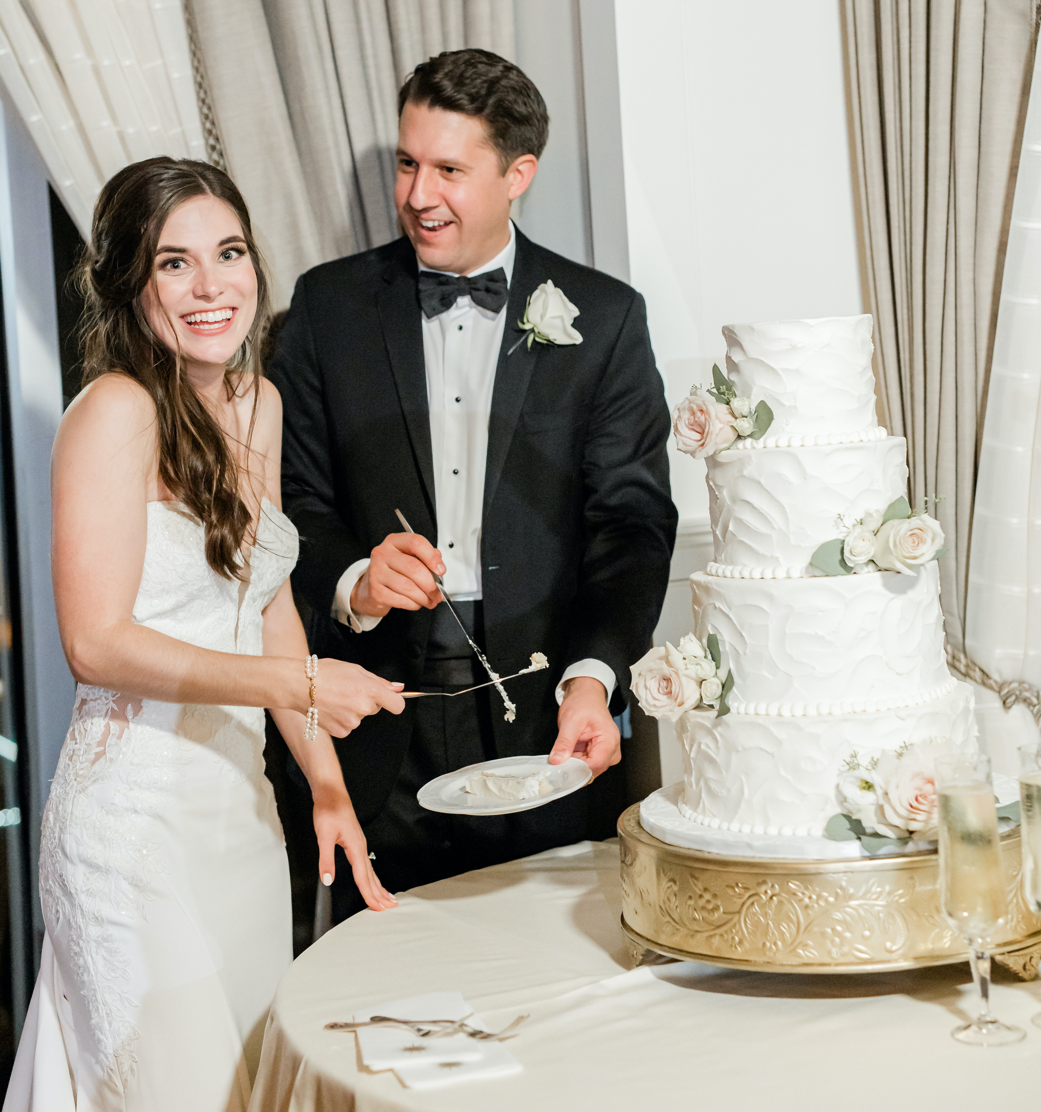 A bride and groom cut their four-tier wedding cake at their reception at The Petroleum Club in Houston.