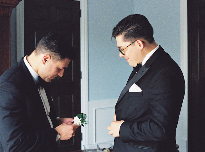 The groom and a groomsmen getting ready before the wedding.