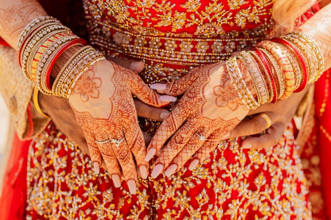 The bride wears traditional Indian wedding attire and henna on her hands for her Indian-fusion wedding in Mexico. 