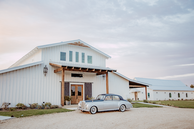 A vintage car parked outside the barn venue, Hummingbird Hill Weddings & Events. 