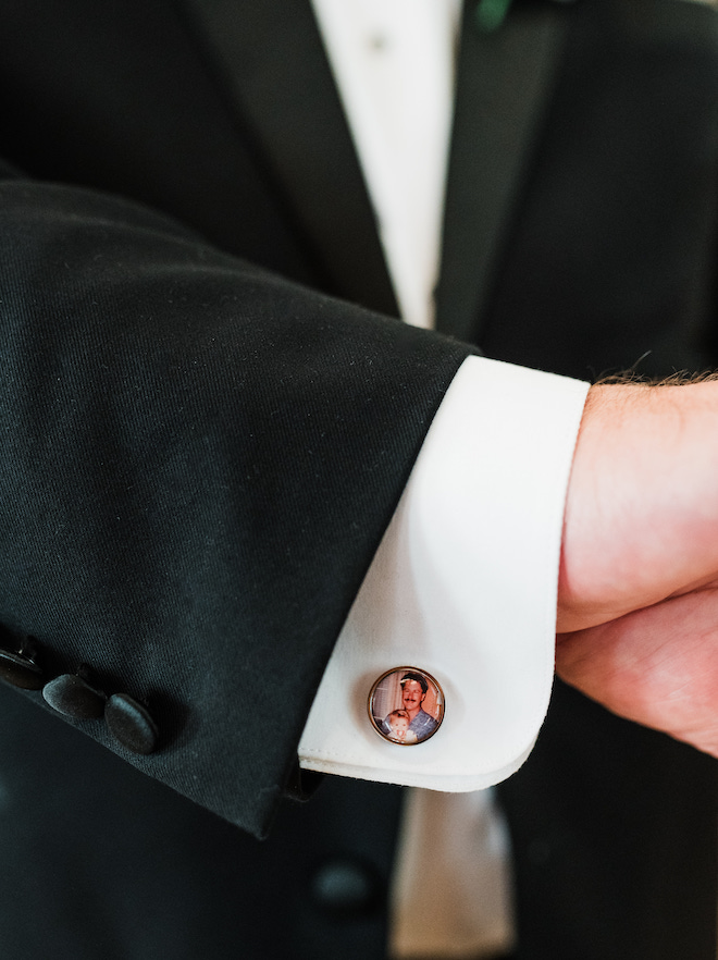 The groom's cufflink with a photo of a man carrying a baby. 