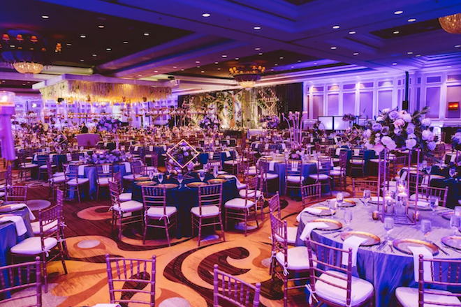 The ballroom of Houston Marriott Sugar Land with purple wedding decor. 