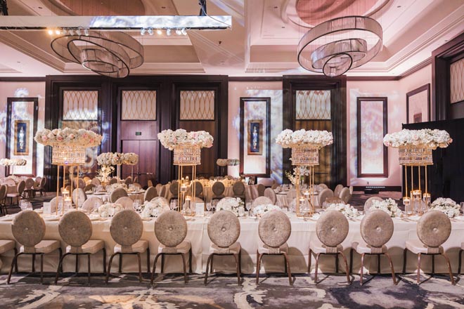 White flowers and candles decorate the glamorous ballroom reception in Houston.