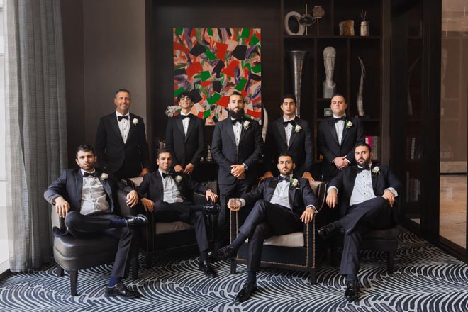 The groom and his groomsmen wear tuxedos for the wedding ceremony.