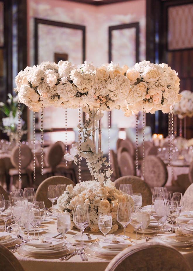 White floral centerpieces with handing diamonds detail the reception tables.
