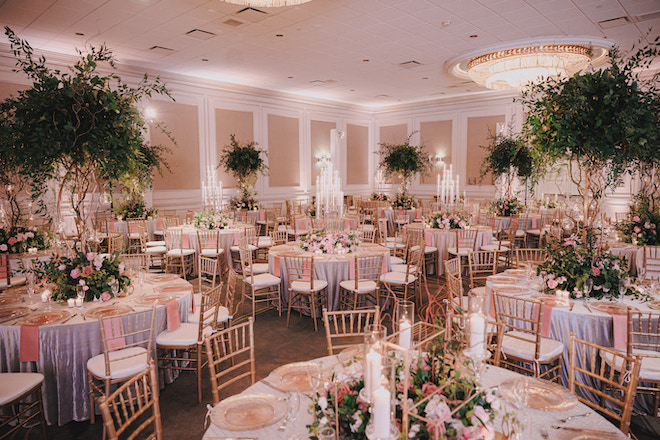 The Westin Galleria ballroom with round tables decorated with blush linens and greenery. 