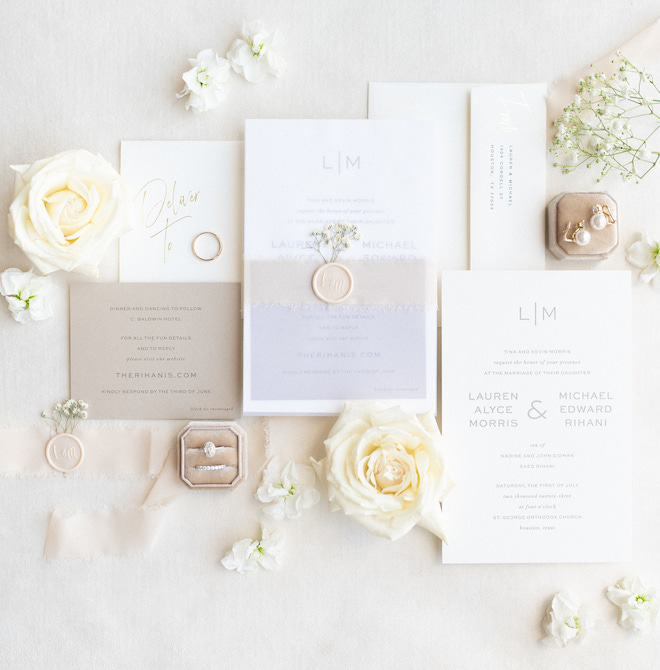 A white, champagne and light blue invitation suite. 