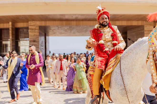 At his baraat, the groom rides in on a horse to his outdoor Hindu ceremony in Puerto Vallarta, Mexico.