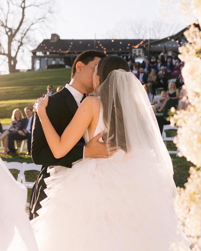The bride and groom share a kiss at their sun-kissed al fresco wedding at Hyatt Regency Lost Pines Resort & Spa.