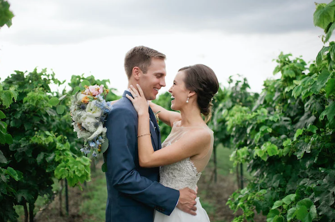A bride and groom smiling at each other in a wine vineyard in Fredericksburg, Texas. 