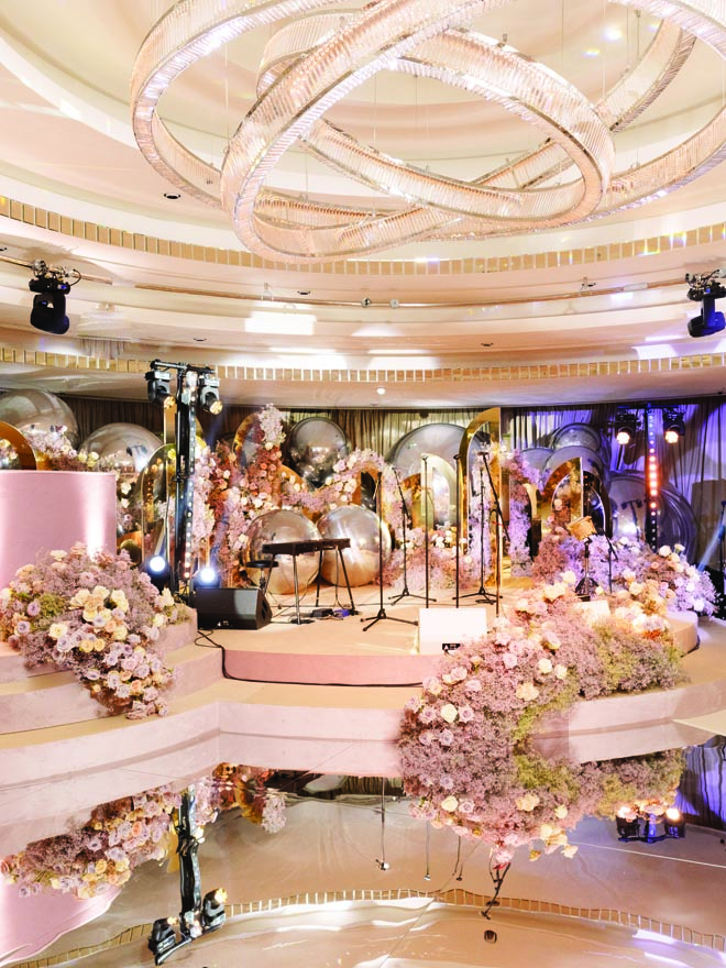 Blush, ivory and lavender-colored flowers and silver and gold accents decorate the stage. 