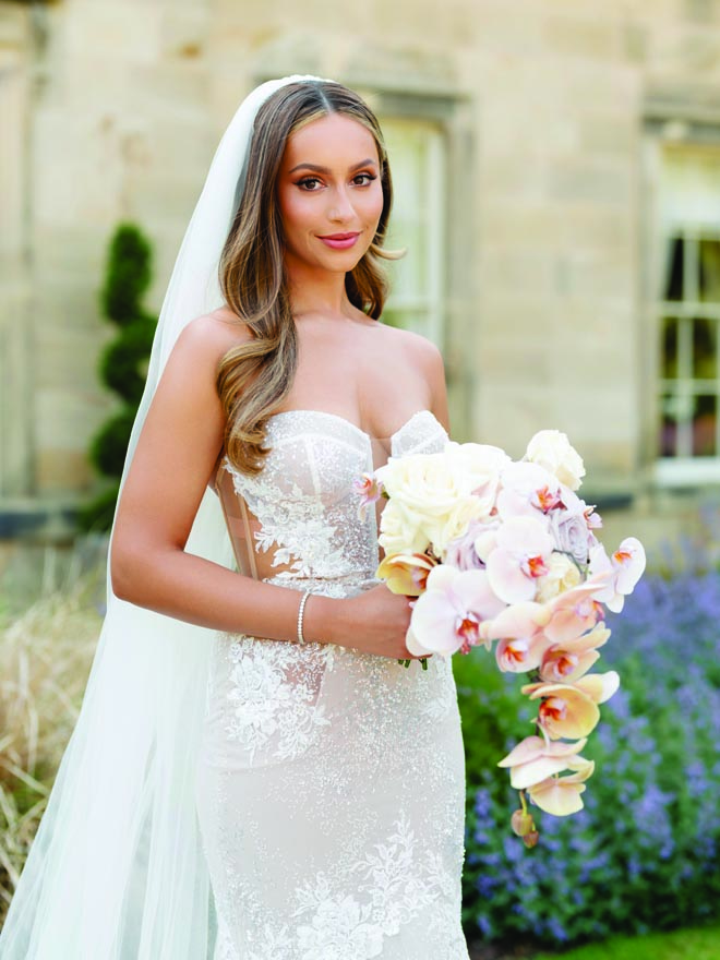 The bride has a pink and lavender wedding bouquet with orchids for her storybook wedding. 
