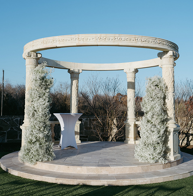 The outdoor ceremony space with two baby's breath pillars. 