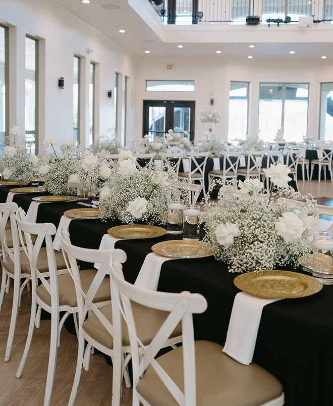 Long reception tables covered in baby's breath and gold accents. 
