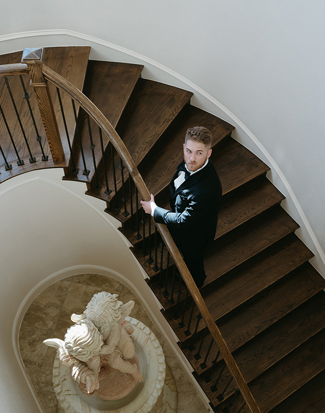 The groom walking up a spiral staircase. 
