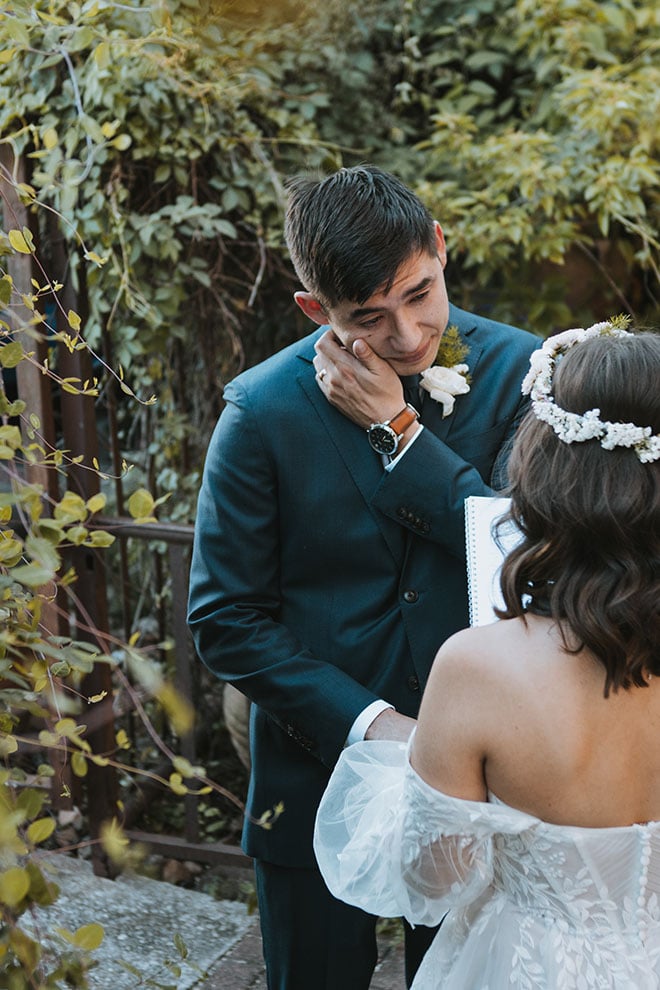 The groom wipes tears from his face during the couple's private vows.