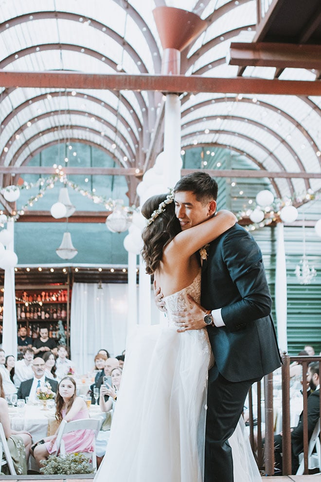 Wedding guests watch as the bride and groom share their first dance. 