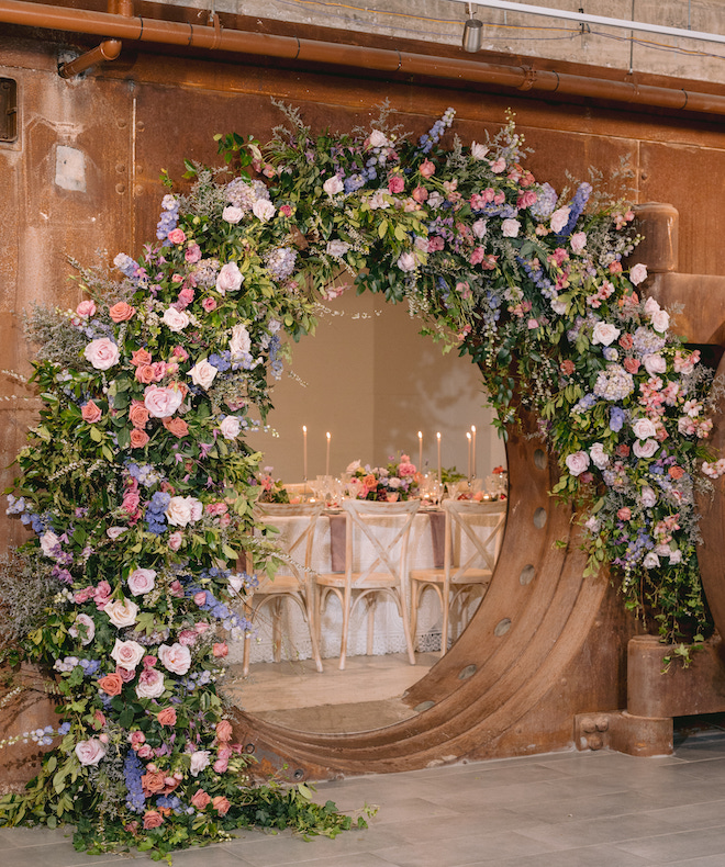 A floral installation with greenery, pink, blue and white florals on the entryway of The Vault at Corinthian Houston.