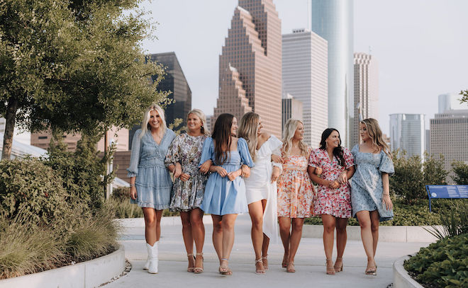 A group of friends walk on the rooftop of the wedding venue, POST Houston.