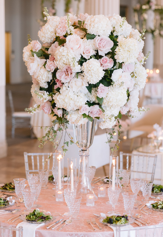 A large blush and white floral centerpiece on a circular table. 