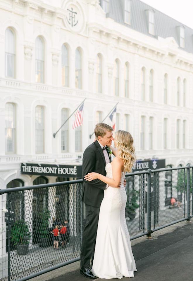 The bride and groom stand on the terrace outside their wedding venue, The Tremont House.