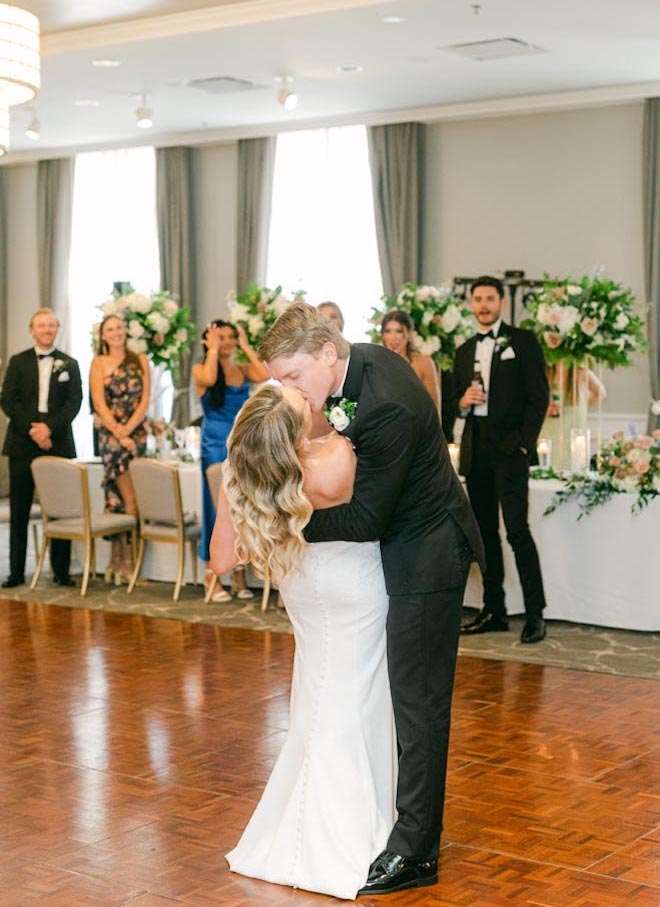 The bride and groom share a kiss during their first dance at their light and airy wedding.