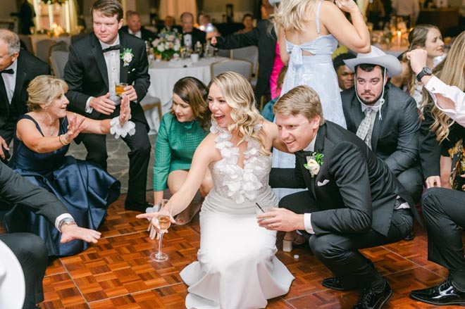 The bride and groom dance with their guests at their ballroom reception.