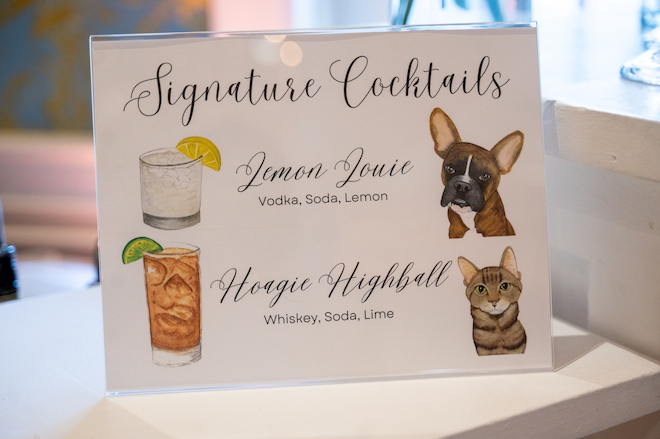 A signature cocktails menu with a dog and a cat and two drinks. 