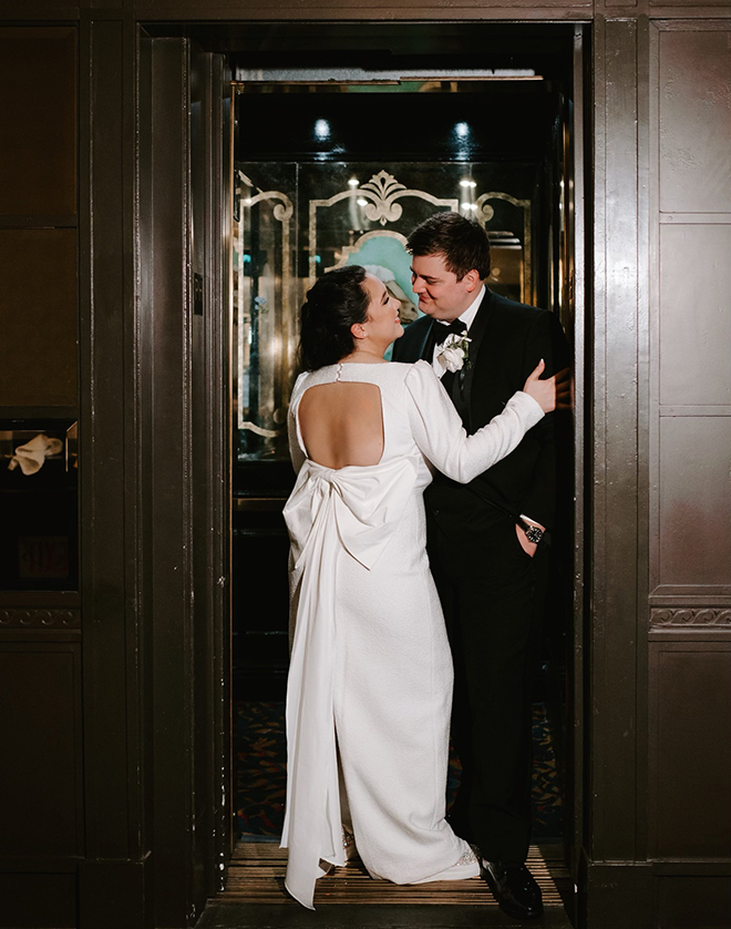 The bride and groom smiling at each other in the elevator of Hotel ICON.