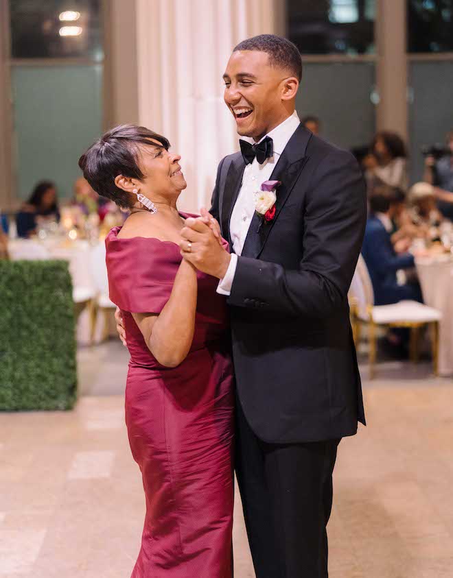 A groom and his mother laughing while dancing. 