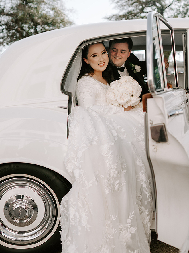 Bride and groom sitting in the back seat of a vintage Bentley. 