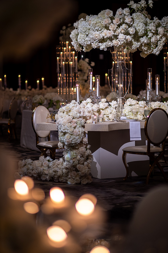 White roses and floral arrangements decorate the tables at the grand ballroom reception at The Post Oak Hotel.