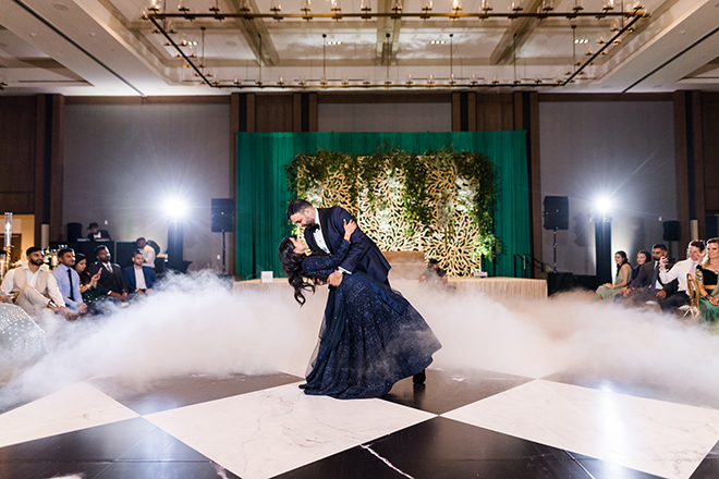 The groom dipping the bride on a black-and-white checkered dance floor with fog.