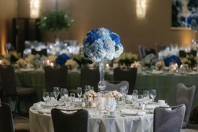 Blue hydrangeas detail the reception tables in the venues ballroom.