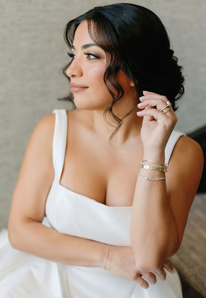 The bride poses while sitting on the stairs in the penthouse suite of the JW Marriott Houston by the Galleria.