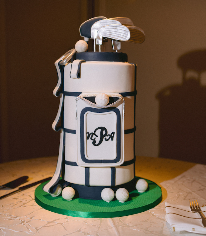 A groom's cake designed into a gold bag with golf balls, gold clubs, and the intials N,P,A written on the front. 