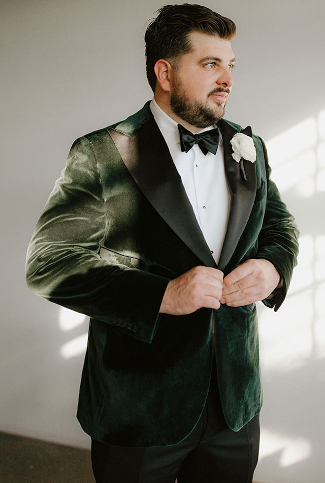 The groom wears a velvet and emerald green tuxedo for his wedding at The Astorian.