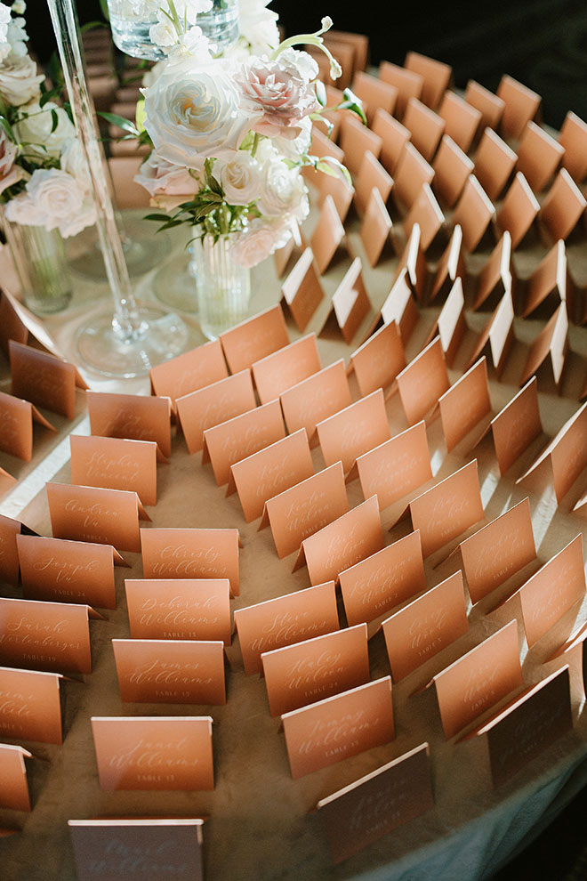 The couple has copper seating cards for their wedding reception.