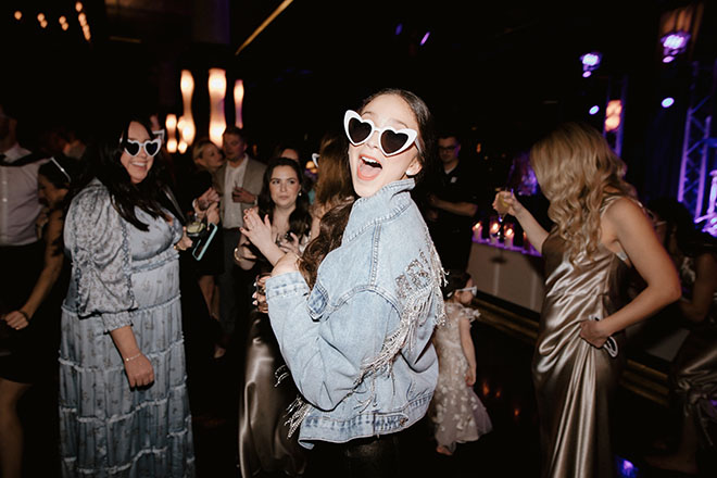 The bride wears heart shaped glasses during her wedding reception in Houston.