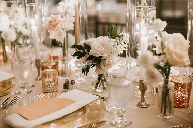 White and pink roses and lit candles detail the reception tables.