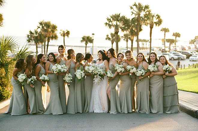 The bride and her bridesmaids hold their bouquets outside of the wedding venue in Galveston.