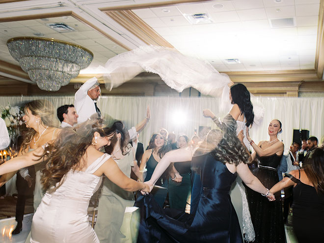 The bride and groom celebrate with friends and family at their beachside wedding in Galveston, Texas.