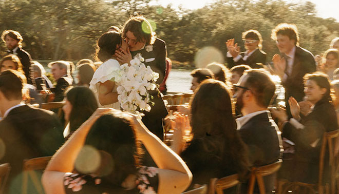 The bride and groom make their way down after saying their "i do's" and kiss at the end. 