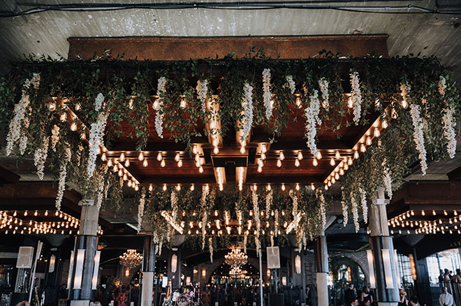 Greenery and white florals hang from the ceiling. 