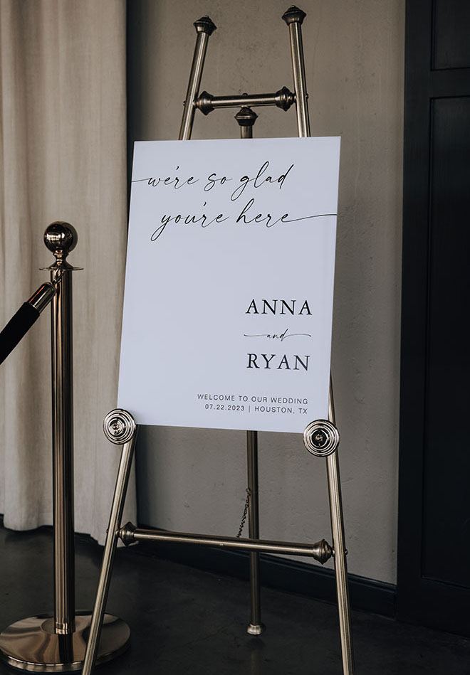 A stationery sign greeting guests is placed in front of the entrance to the wedding ceremony.