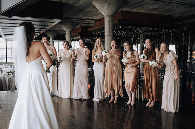 The bride does a first look with her bridesmaids before the wedding ceremony.