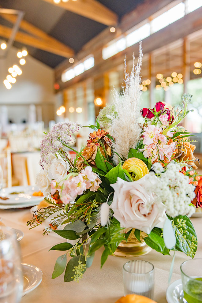 Autumn-inspired wedding florals decorate the reception tables.