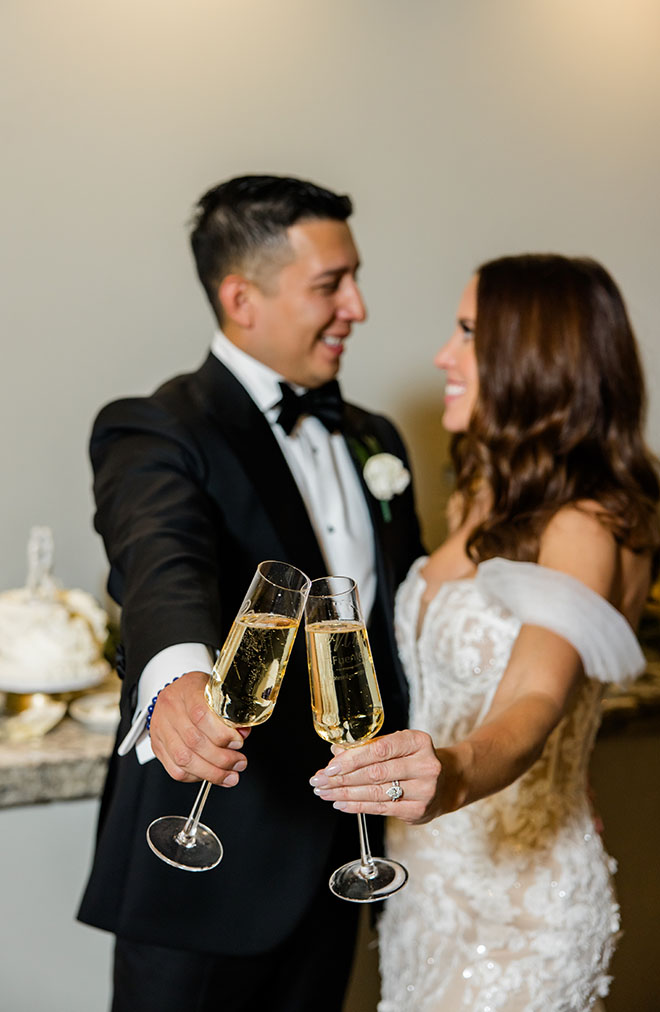 The bride and groom toast with a glass of Champagne at their autumn-inspired wedding reception.