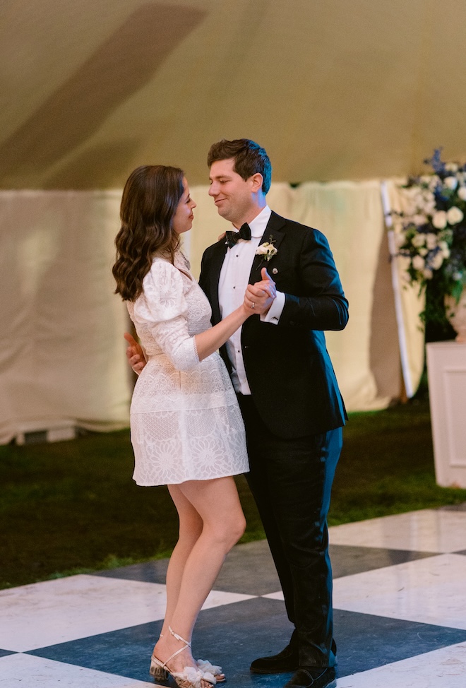 The bride and groom share a private last dance on a blue and white checkered dance floor. 