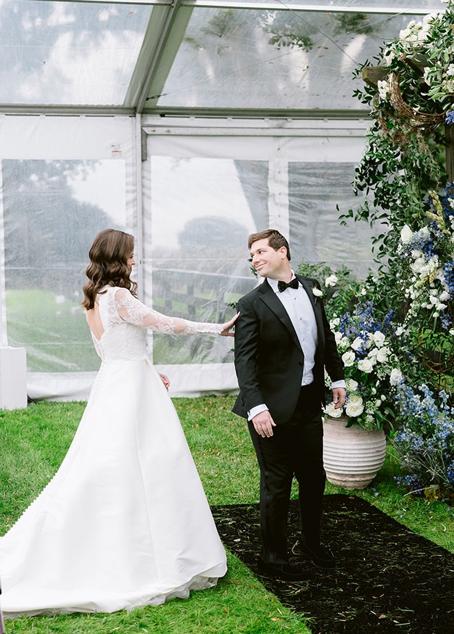 The bride taps the groom on his shoulder during their first look. 